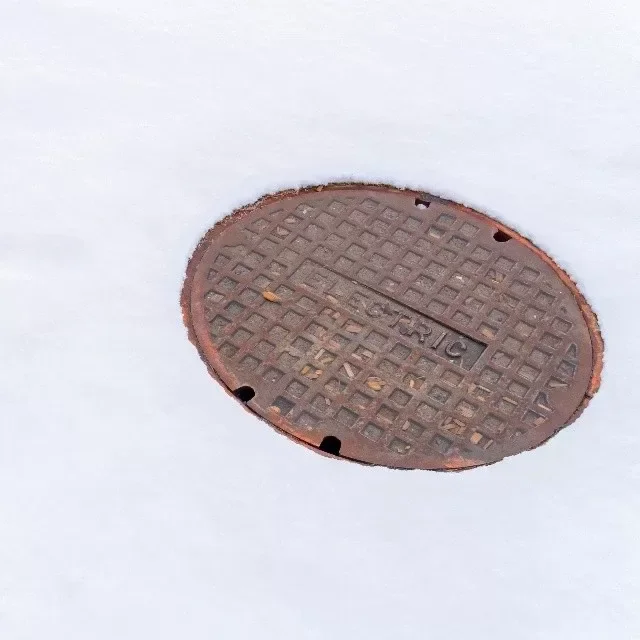 Kanalizační poklop zasypaný sněhem