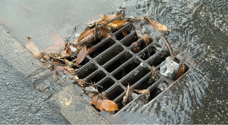 Ucpávání betonové skruže listím a petlahví